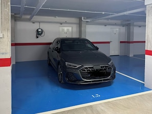 A parking garage with a blue floor and white walls, featuring a black car parked in a designated space. - Luxury Golf View | Pool | EV Charger | Near the Beach (Los Alcázares)