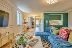 A spacious living area with a large sofa, a coffee table, and a television.