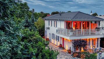 Een herenhuis met een balkon, omringd door groen.