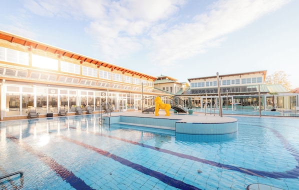 A swimming pool with a lifeguard chair and a yellow statue.