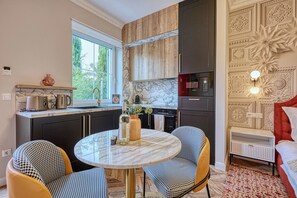 Una cocina moderna con armarios oscuros, encimera de mármol y horno Bosch.
