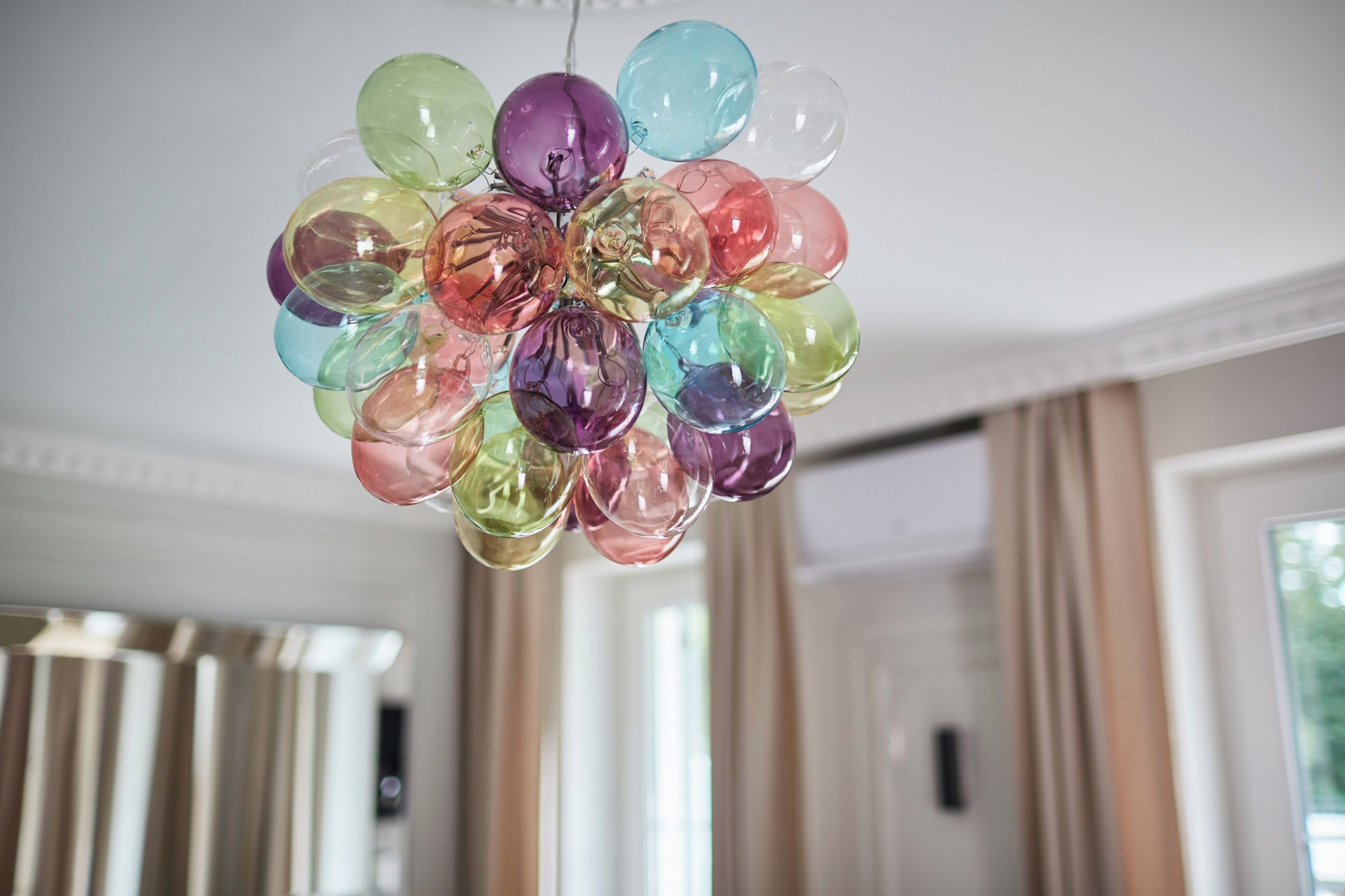 A chandelier with multiple glass orbs in various colors.