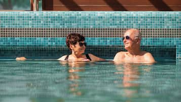 A swimming pool with tiled walls and a wooden structure in the background.