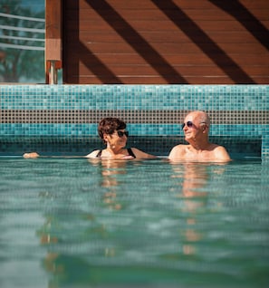 A swimming pool with tiled walls and a wooden structure in the background. - The Doors Apartments (Mosonmagyaróvár)