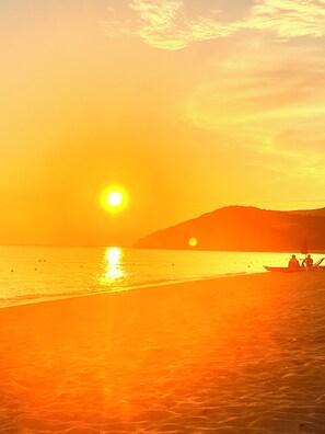 A beach scene with a boat and people, a clear sky, and a sunset. - Cozy home just a 5-minute walk from the beach, along Geremeas Bay (Geremeas)