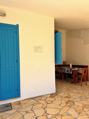 A room with a blue door, a table with chairs, and a sign on the wall. - Cozy home just a 5-minute walk from the beach, along Geremeas Bay (Geremeas)