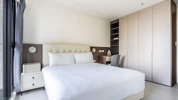 Una habitación de hotel moderna con una cama grande, una mesita de noche, una silla y un armario.