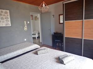 A bedroom with two beds, a desk, and a chair. - Holiday home in Karlobag with seaview (Karlobag)