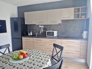 A compact kitchen with a microwave, a sink, and a fruit bowl on the table. - Holiday home in Karlobag with seaview (Karlobag)