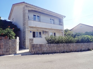 A two-story building with a stone facade, a balcony on the upper floor, and a gated entrance. - Holiday home in Karlobag with seaview (Karlobag)