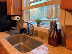 A kitchen with a stainless steel sink, a dish rack, a bottle of Dawn dish soap, and a knife block. - Superb 3-bedroom cabin with AC in delightful San Jose (San Jose)