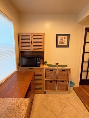 A compact kitchen with a microwave, a coffee maker, and storage baskets. - Superb 3-bedroom cabin with AC in delightful San Jose (San Jose)