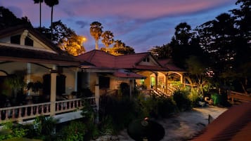 A residential property with a covered porch, a staircase, and a well-maintained garden.