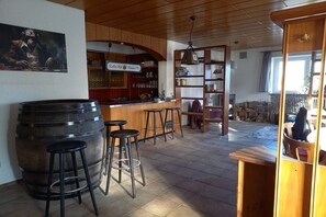 A bar area with stools, a wooden counter, and shelves with bottles. - Holiday apartment with 3 bedrooms (Mühlingen)