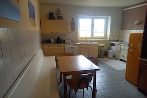 A compact kitchen with a dining table, a sink, and a refrigerator. - Holiday apartment with 3 bedrooms (Mühlingen)