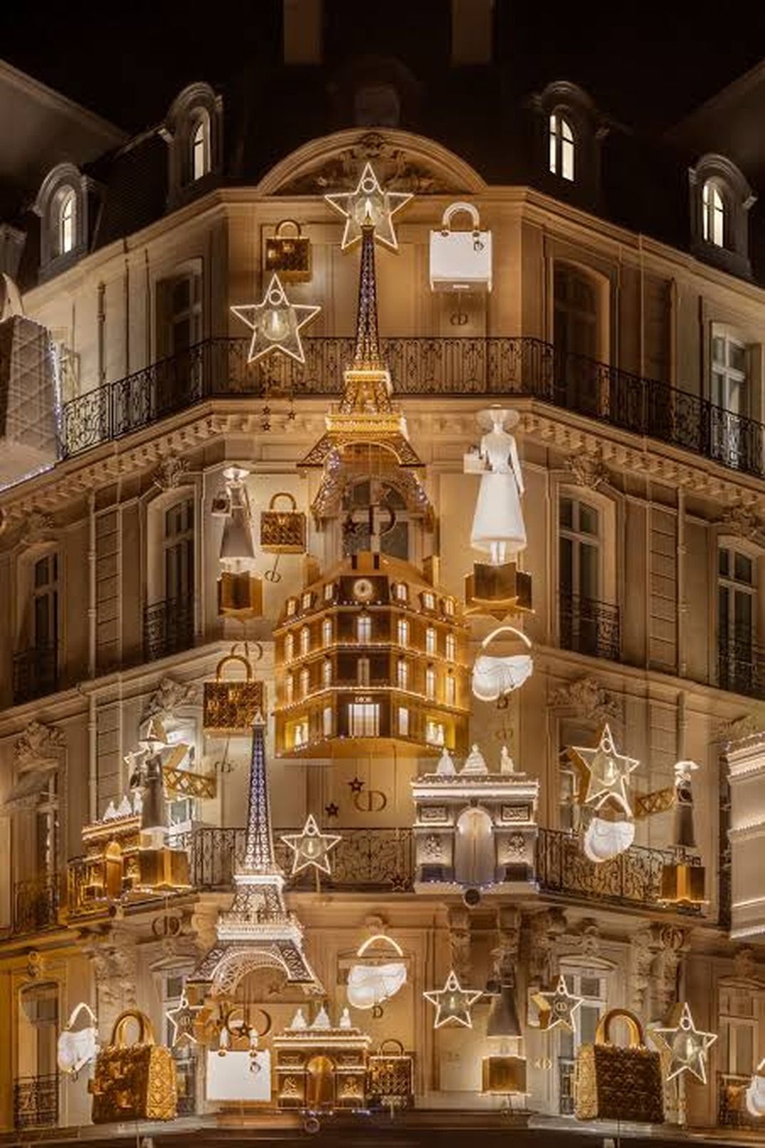 A building facade with multiple balconies, star-shaped decorations, and a prominent Eiffel Tower model.