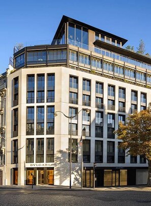 A modern building with multiple floors, large windows, and storefronts. - 200 m² Luxury on the Seine: Alma, George V, Montaigne (Paris)