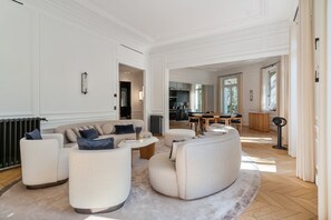 A spacious living room with a sofa set, a coffee table, and a dining area with a table and chairs. - 200 m² Luxury on the Seine: Alma, George V, Montaigne (Paris)