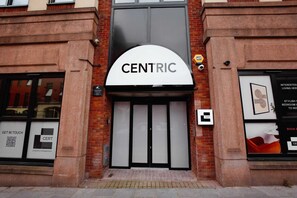 A building entrance with a sign reading 'CENTRIC' above a set of double doors. - Modern City Centre Apartment| Moorfields| Sofa Bed (Merseyside)