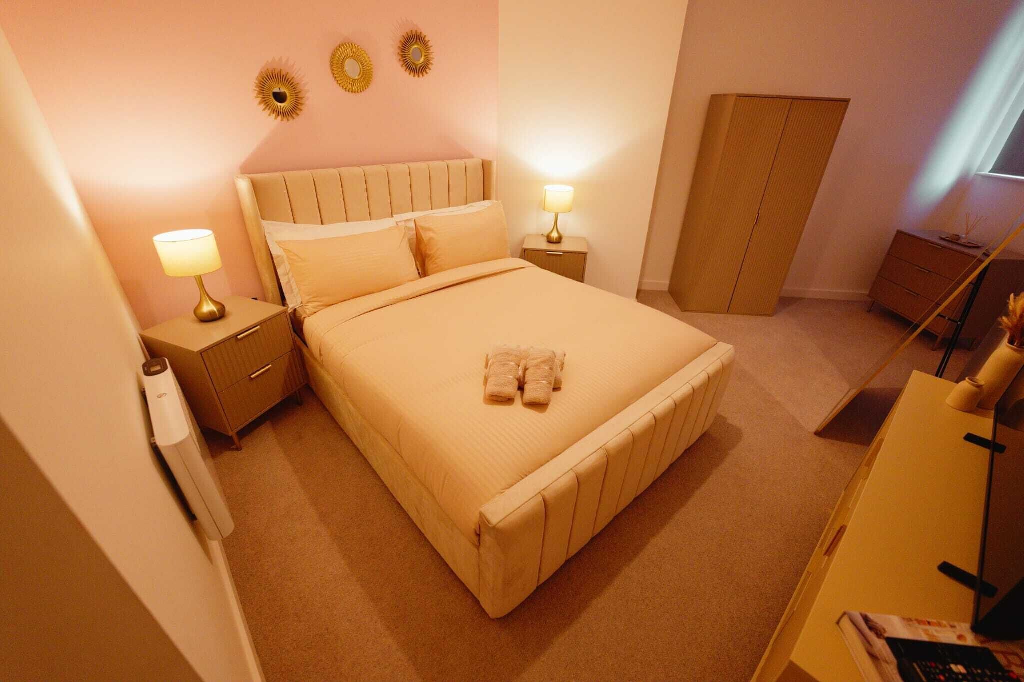Une chambre d’hôtel comprenant un lit, des tables de chevet, une armoire et des éléments de décoration murale.