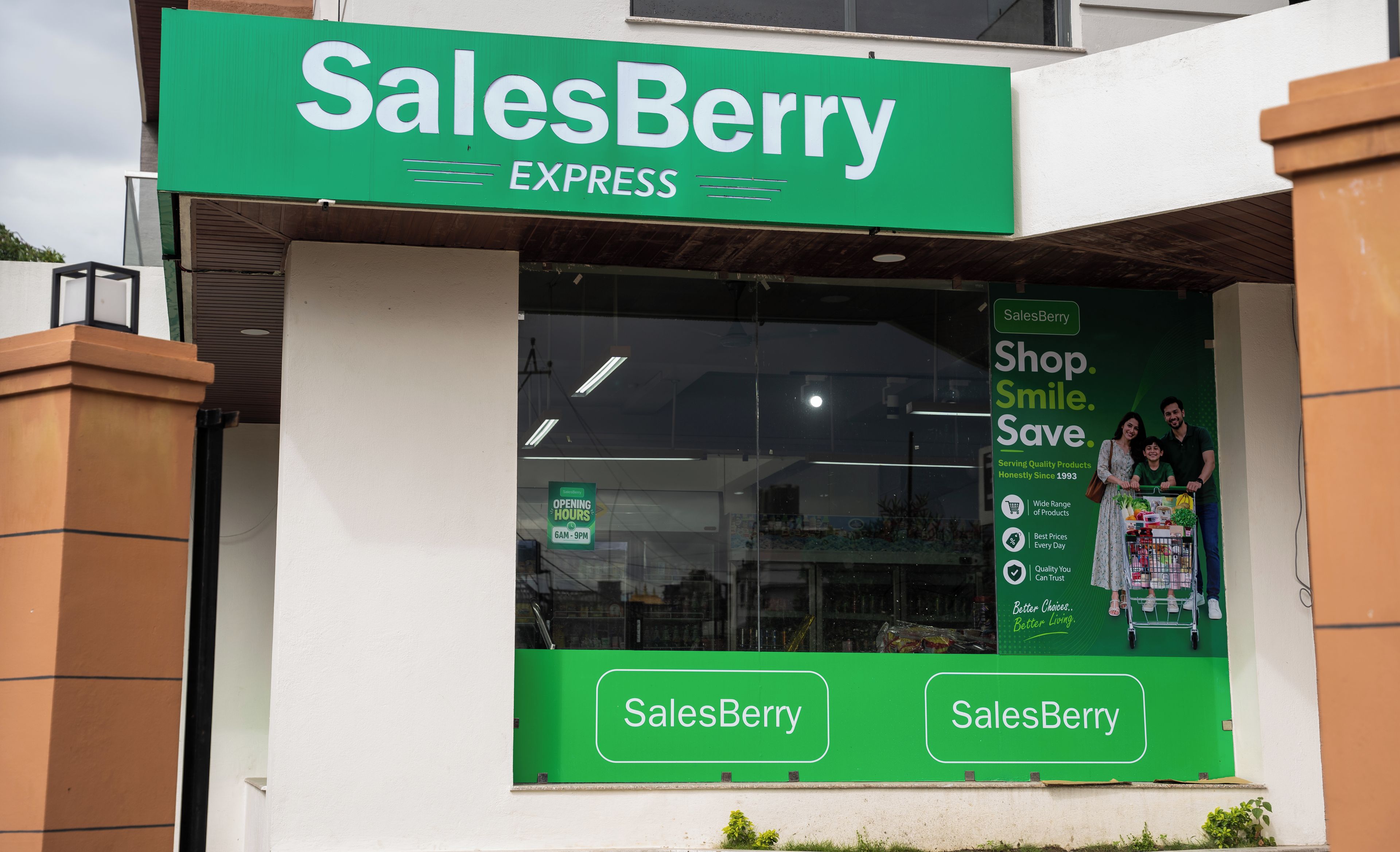 Un escaparate con un letrero verde que dice 'SalesBerry EXPRESS' y un amplio ventanal que muestra a una familia comprando.