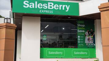 Un escaparate con un letrero verde que dice 'SalesBerry EXPRESS' y un amplio ventanal que muestra a una familia comprando.