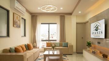 A modern living room with a sofa, a coffee table, and a TV mounted on the wall.