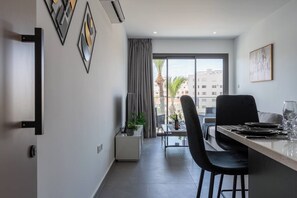Ein moderner Essbereich mit einem Tisch für zwei Personen, Blick ins Freie und minimalistischer Einrichtung.