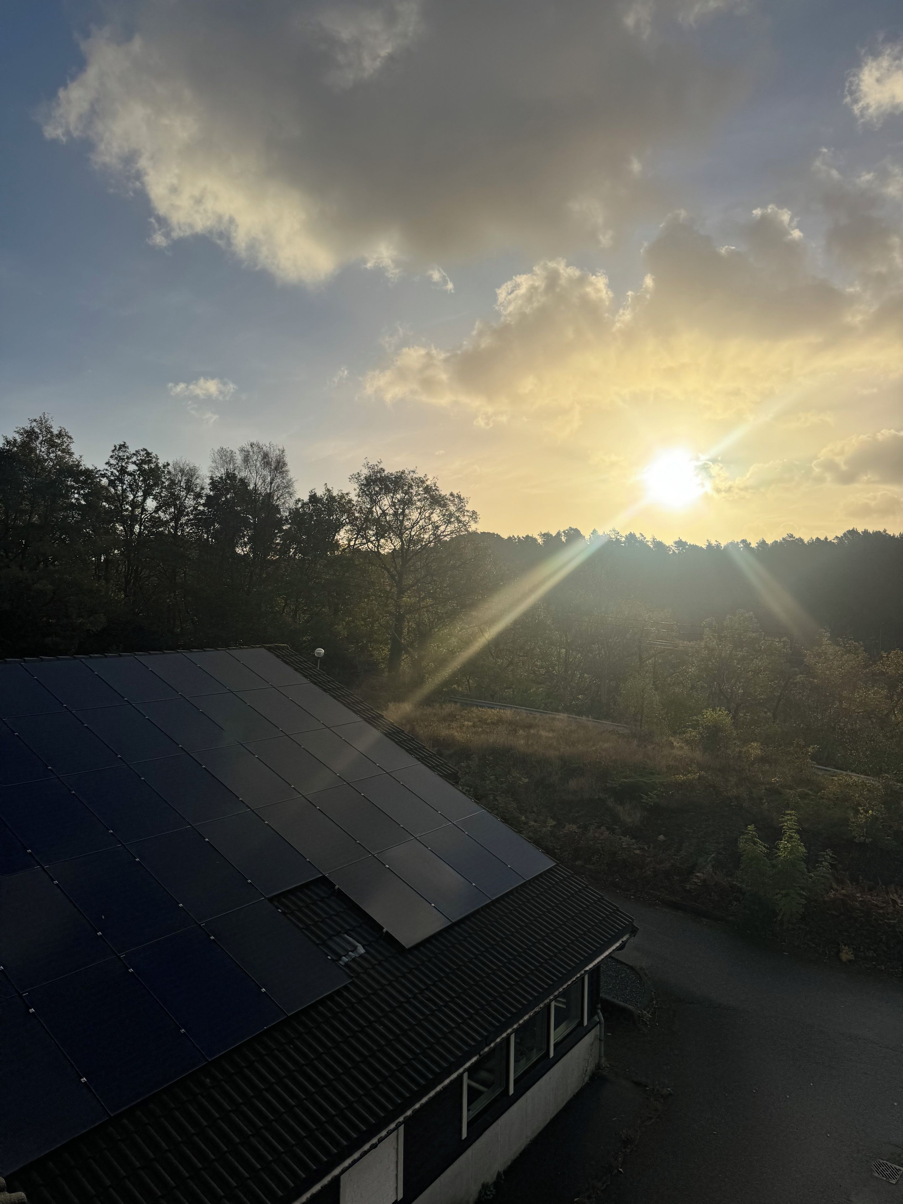 Un edificio con techo inclinado, cielo despejado y luz solar.