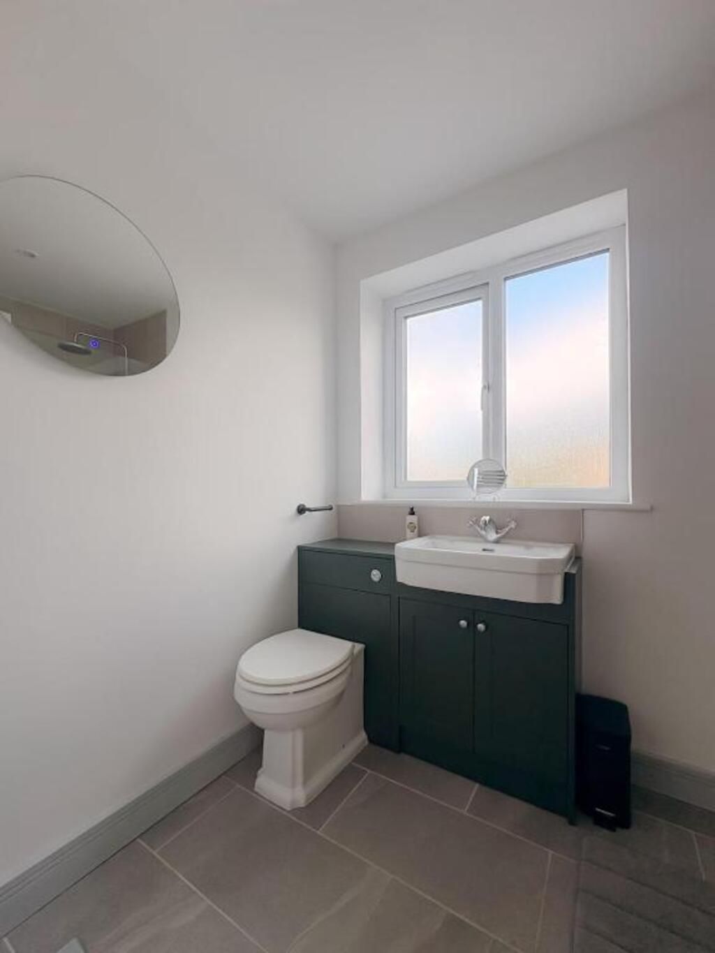 Un baño con inodoro, lavamanos y espejo.