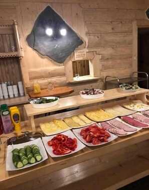 Een buffet met diverse gerechten en bijbehorende sauzen en kruiden.