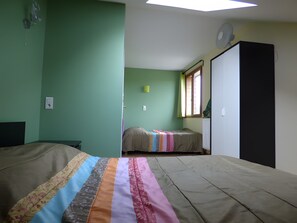 A room with two beds, a window with curtains, a radiator, and a fan on the wall. - Holiday Home 'Gîte Lauberoye' with Private Terrace, Private Garden and Wi-Fi (Saint-Pierremont)
