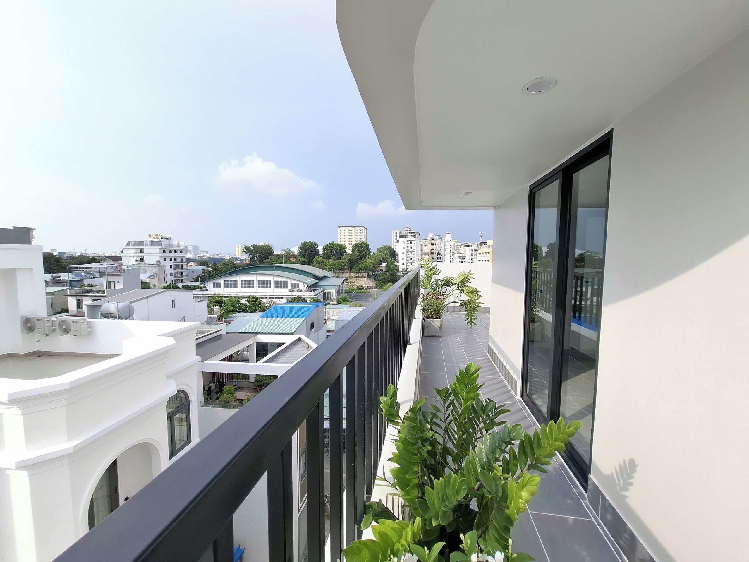 Un balcon offrant une vue sur les bâtiments environnants et un ciel dégagé.