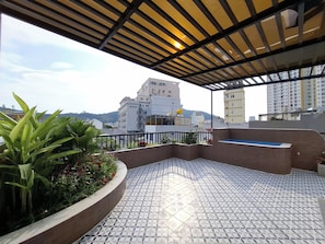 A rooftop terrace with a patterned floor, a small pool, and a view of surrounding buildings. - Olive House by the Beach - Elevator & Kitchen (Vung tau)