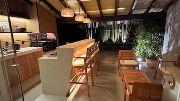 Cozinha moderna com área de bar, mobiliário de madeira e vista para o exterior.