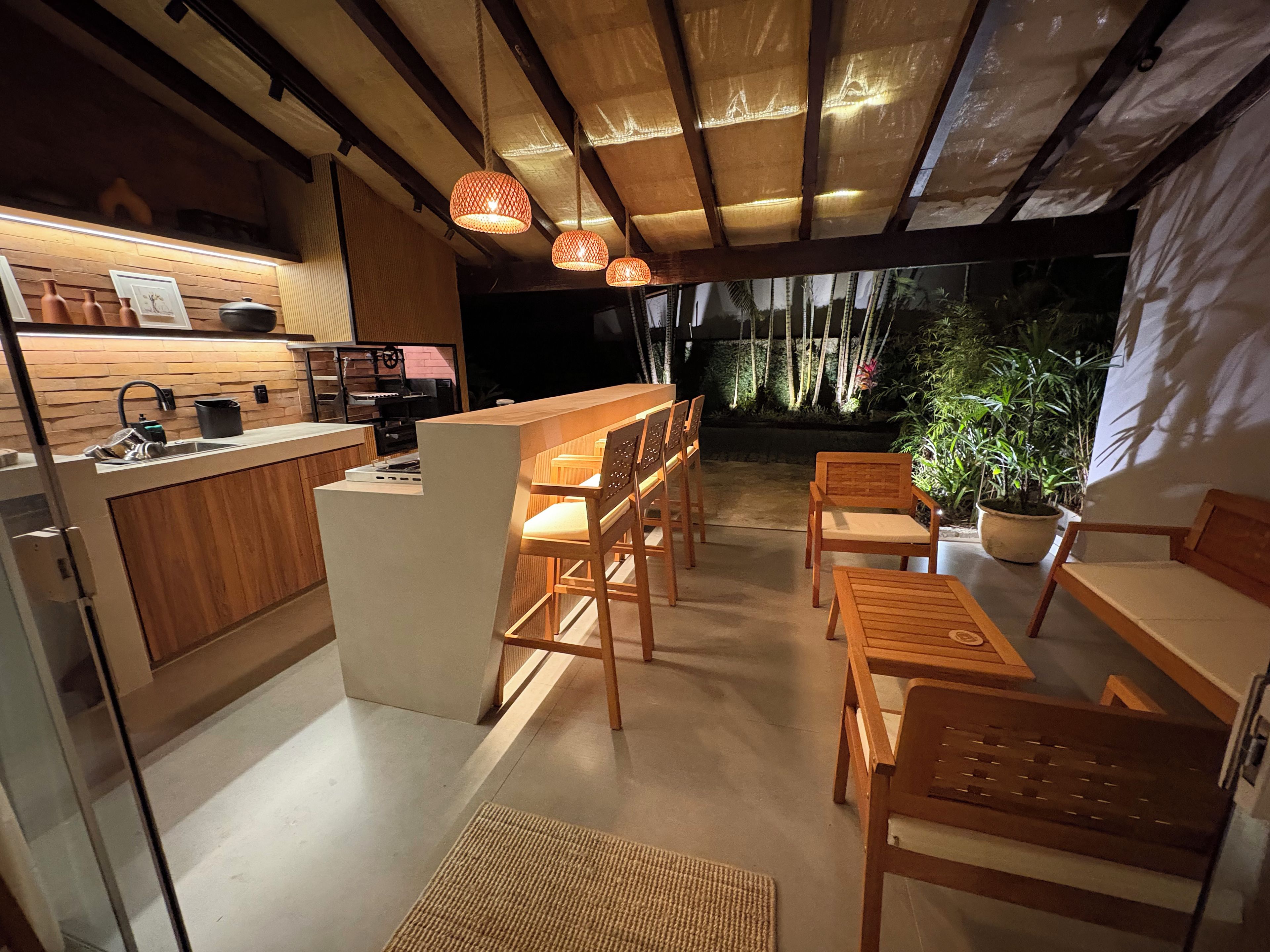 Una cocina moderna con muebles de madera, una isla central e iluminación colgante.