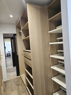 A walk-in closet with multiple shelves and hanging space.