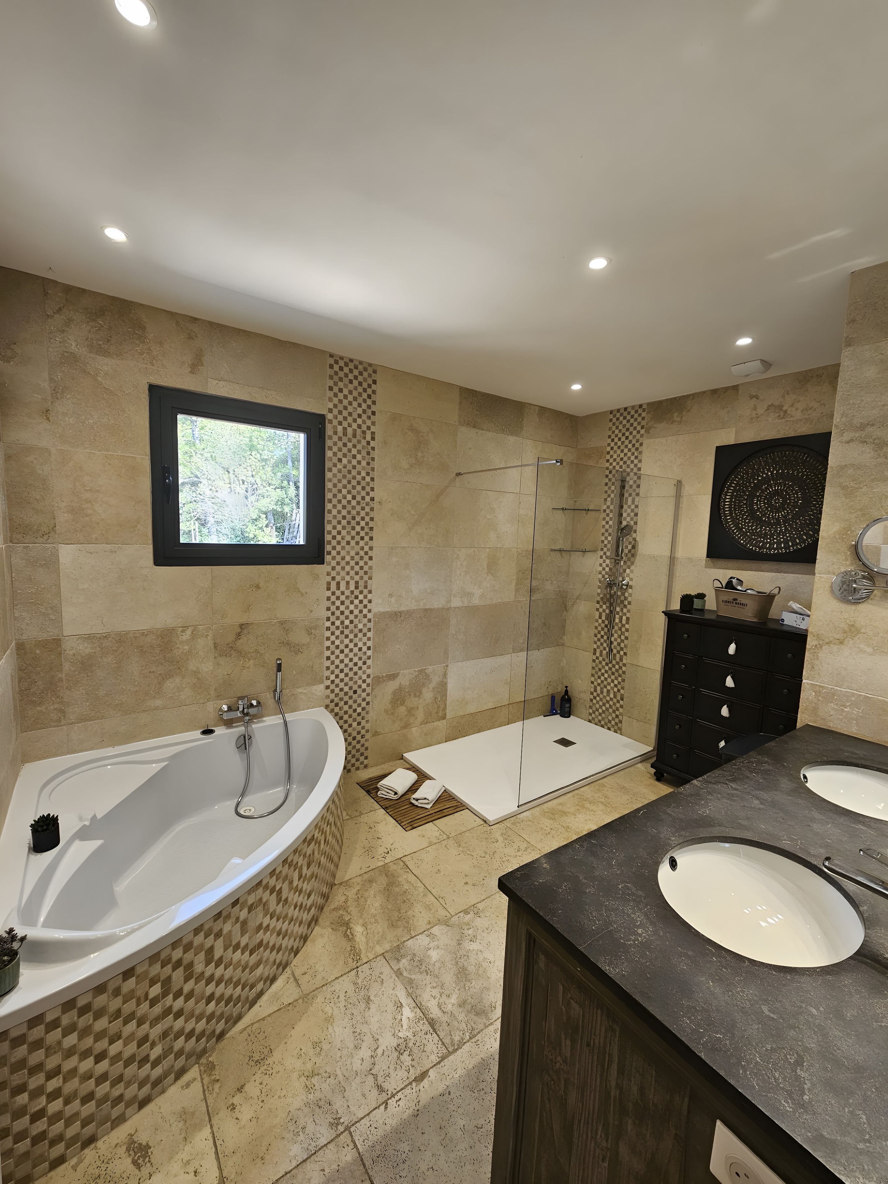 Une salle de bain moderne avec une baignoire sur pieds, une douche à l’italienne et un meuble-lavabo doté de deux vasques.