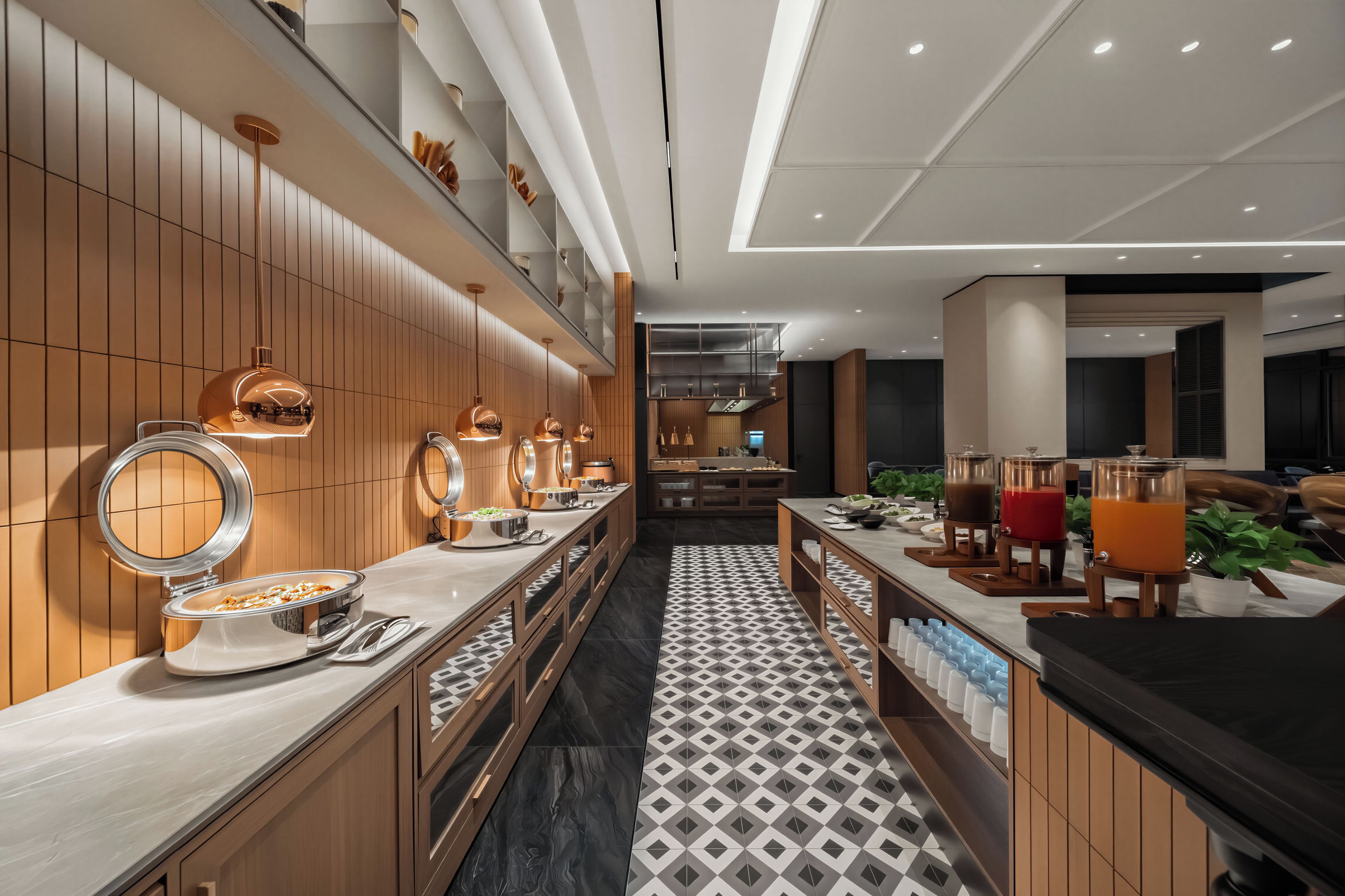 Un hall d’hôtel moderne avec un long comptoir d’accueil, un miroir et un espace dédié au café.
