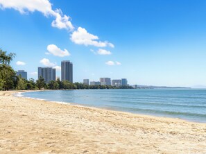 A beach with a city skyline in the background.