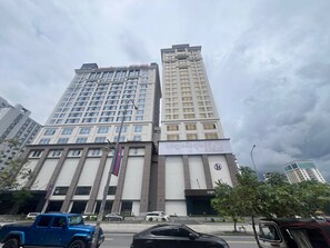 A multi-story building with a prominent sign, likely a hotel or commercial property, with a clear sky in the background. - HUA RUI HOTEL (Preah Sihanouk)