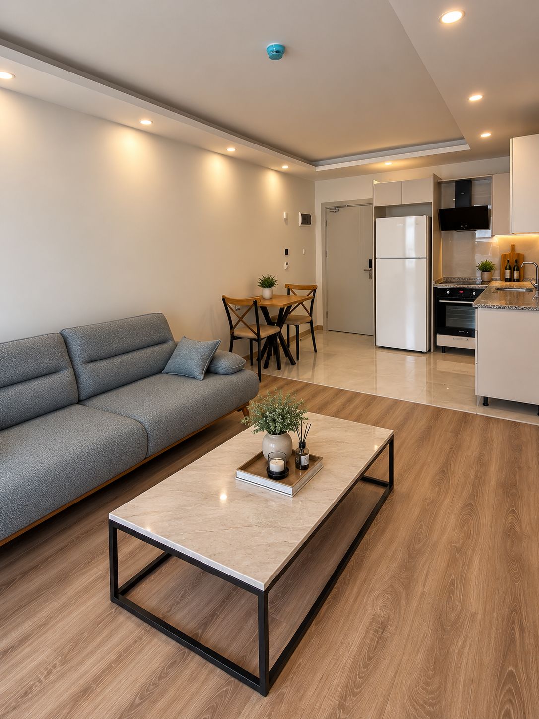 A modern living room with a sofa, a coffee table, and a dining area with a table and chairs.