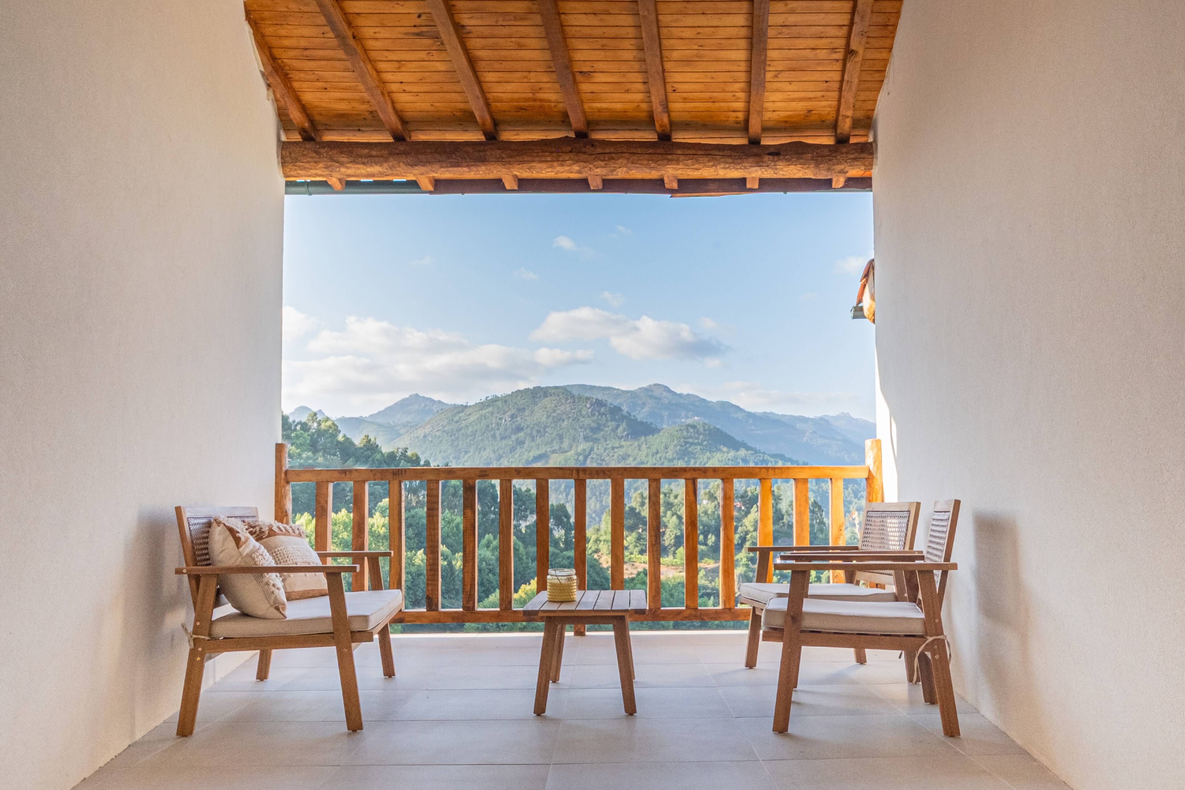 Ein Balkon mit Holzmöbeln und Blick auf Berge.