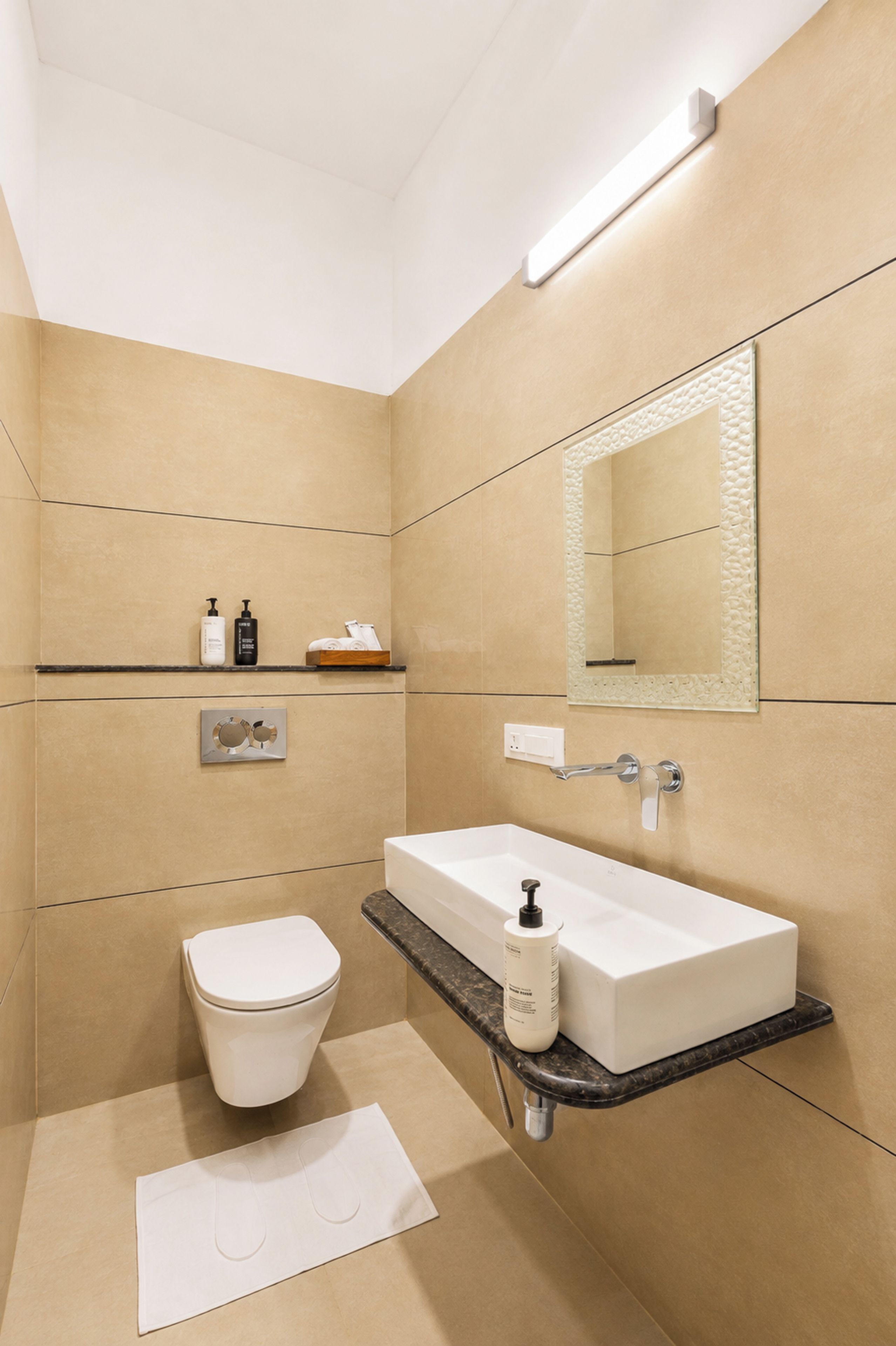 A modern bathroom with a toilet, sink, and mirror.