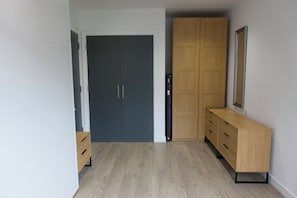 Ein Flur mit einer dunklen Tür, einem Holzschrank und einem Holzkommoden.