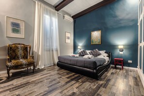 A bedroom with a bed, a chair, and artwork on the walls. - Charming Apartment on the Rome Terrace Near the Pantheon (Roma)