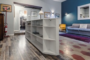 A modern living room with a white shelving unit, a sofa, and a patterned rug. - Charming Apartment on the Rome Terrace Near the Pantheon (Roma)