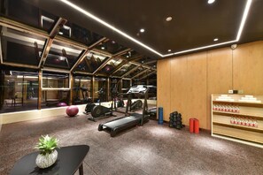 A gym with exercise equipment, a treadmill, a stationary bike, and a water dispenser. - Atour Hotel  Lvshunkou centralsquare (Dalian)