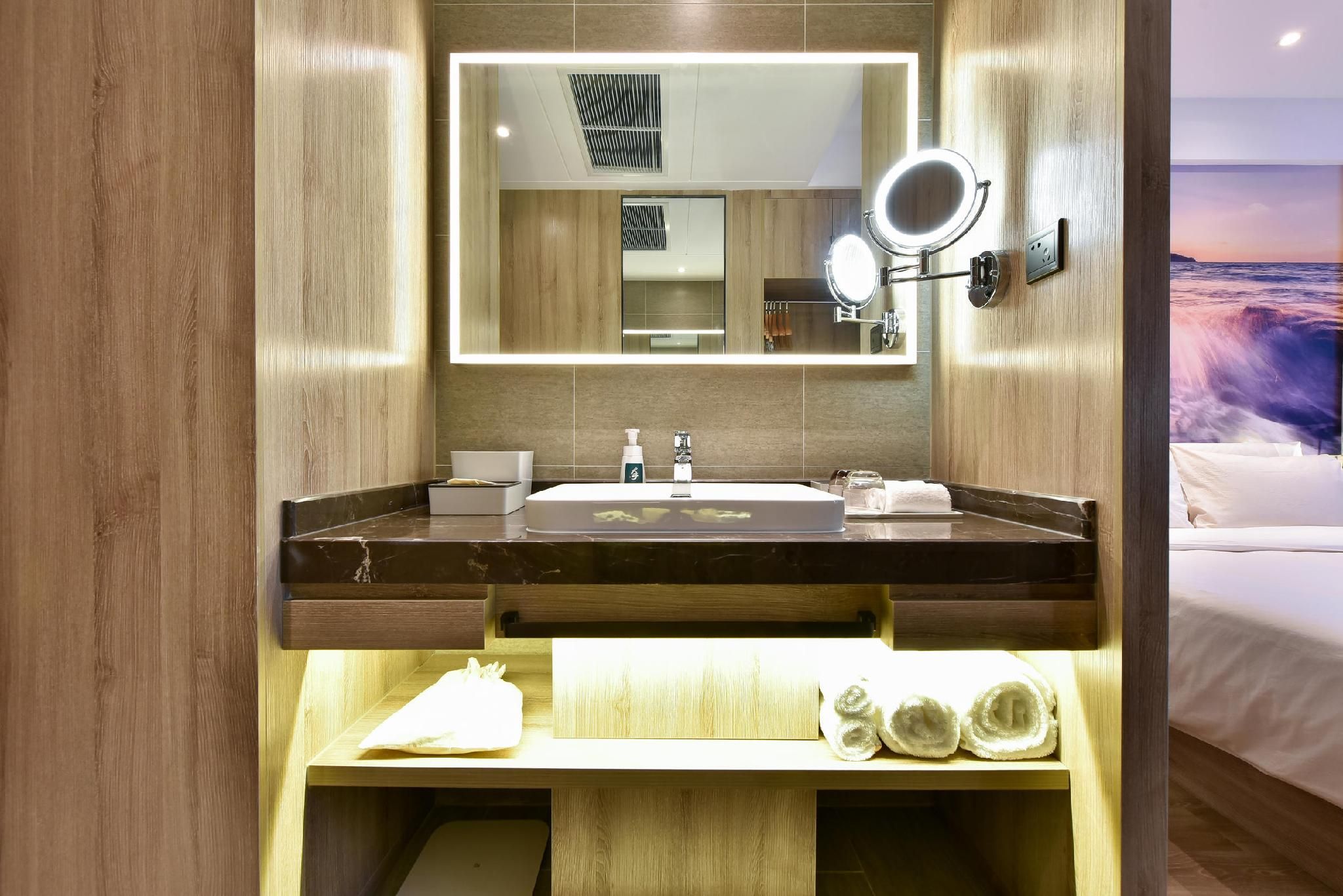 Een moderne badkamer met een grote spiegel, een wastafel en een handdoekrek.