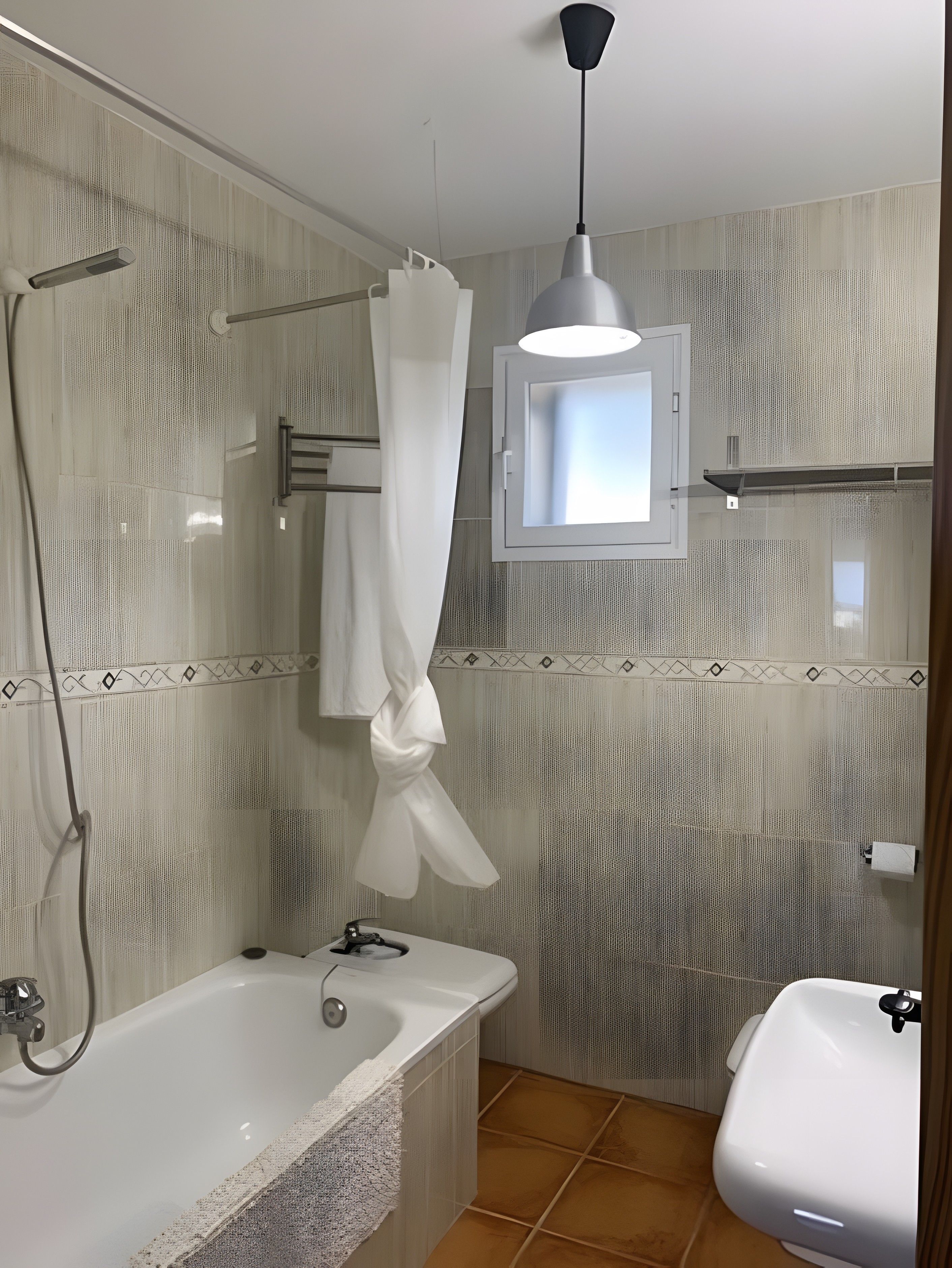 Un baño con bañera, ducha, inodoro y ventana con lámpara.